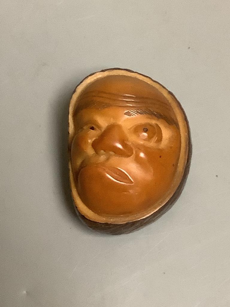 A Japanese carved nut mask netsuke